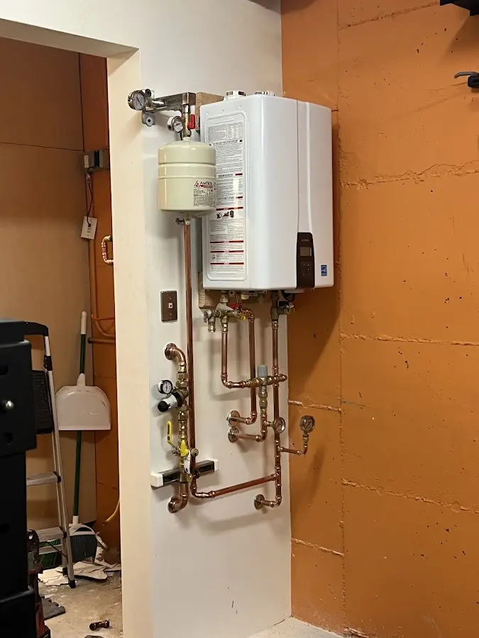 Plumbing technician inspecting water heater connections in Courtland